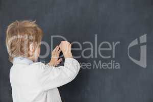 Boy dressed as teacher and writes on black board