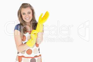 Portrait of smiling young maid with rubber gloves