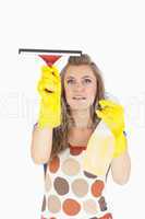 Maid in yellow gloves using wiper and disinfectant spray