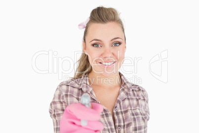 Portrait of smiling young woman holding spray bottle