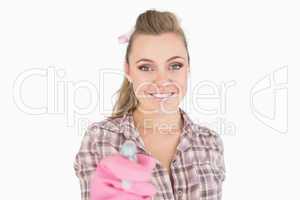 Portrait of smiling young woman holding spray bottle