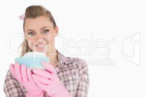 Portrait of smiling woman holding sponge