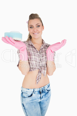 Portrait of smiling woman holding soap suds over sponge