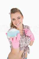 Portrait of happy woman holding soap suds over sponge