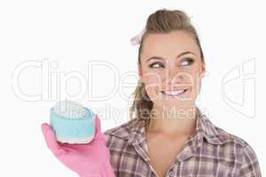 Smiling woman holding soap suds over sponge