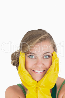 Close-up portrait of smiling young maid with yellow gloves