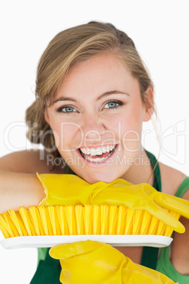 Close-up portrait of cheerful woman with broom