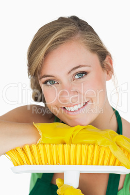 Close-up portrait of young woman with broom