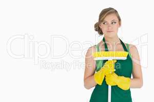 Young woman standing with broom