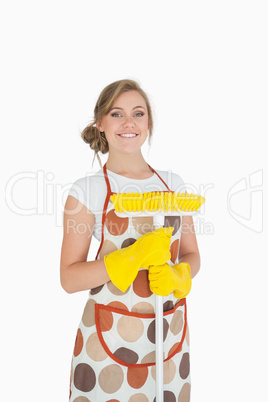 Portrait of smiling young woman with broom