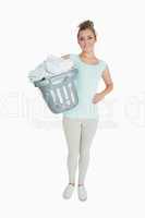 Portrait of young woman carrying laundry basket