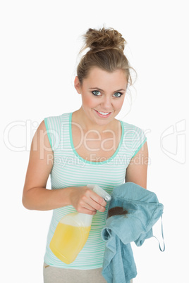 Portrait of woman with spray bottle and stained shirt