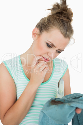 Young thoughtful woman looking at stained shirt