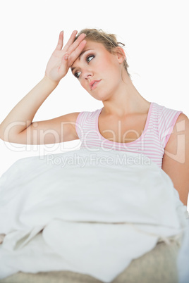 Tired young woman with stack of clothes