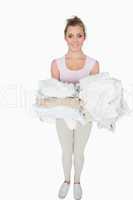 Portrait of smiling woman carrying stack of clothes