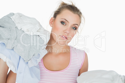 Woman with stack of clothes over white background