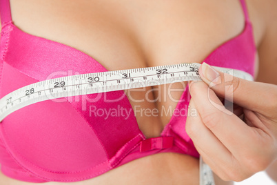 Woman measuring chest in pink bra