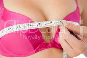 Woman measuring chest in pink bra
