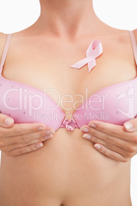 Woman in bra with breast cancer awareness ribbon