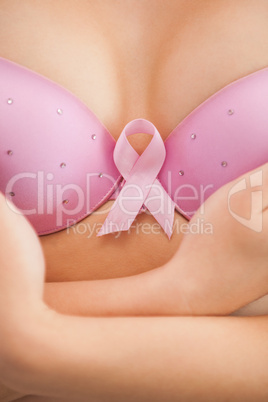 Woman in bra with breast cancer awareness ribbon