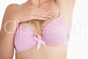 Woman in bra with breast cancer awareness ribbon