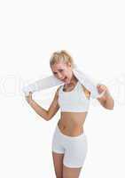 Excited woman in sportswear holding towel around neck