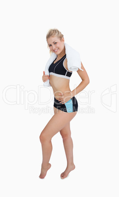 Portrait of happy young woman in sportswear giving thumbs up