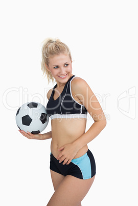 Portrait of happy woman in sportswear with football