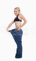 Young healthy woman wearing old pants after losing weight