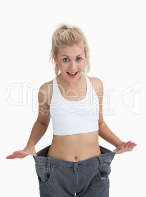 Thin woman wearing old pants after losing weight