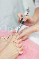 Hands removing callus at feet