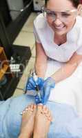 Nail technician removing callus at feet