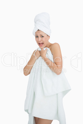 Portrait of woman screaming as she covers herself with towel