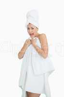 Portrait of woman screaming as she covers herself with towel