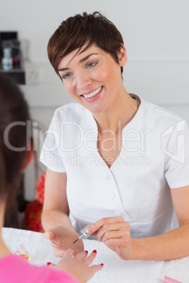 Close-up of woman applying nail varnish to finger nails