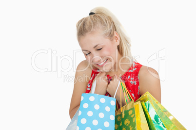 Cute excited young woman with shopping bags