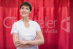 Hairdresser with arms crossed against red curtain