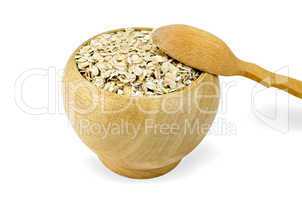 Oat flakes in a wooden bowl with a spoon