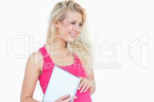 Happy casual woman with digital tablet looking away