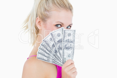 Woman holding fanned banknotes in front of face