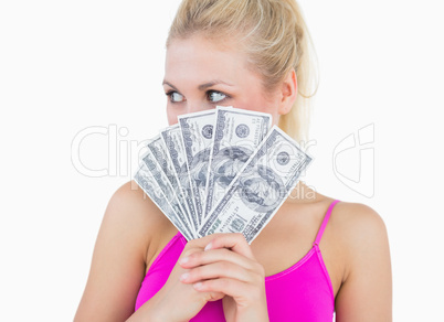 Woman with fanned us banknotes looking away