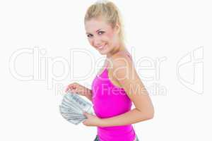 Young casual woman with fanned us banknotes