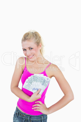 Portrait of happy young woman holding fanned euro banknotes