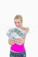 Woman holding out fanned 100 euro banknotes