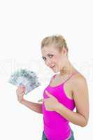 Portrait of happy woman pointing at fanned euro banknotes