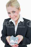 Portrait of business woman holding model house