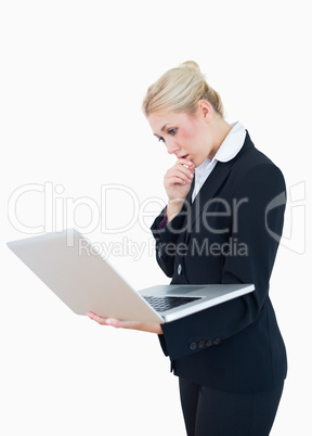 Serious young businesswoman using laptop