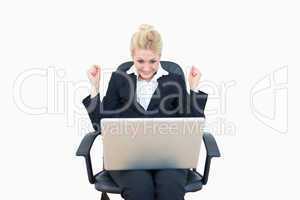 Successful business woman clenching fists in victory with laptop