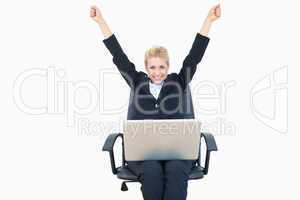 Successful business woman raising hands with laptop