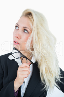 Thoughtful young business woman looking up